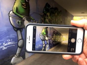 Ein Smartphone wird in der Hand gehalten und eine Wand wird abfotografiert