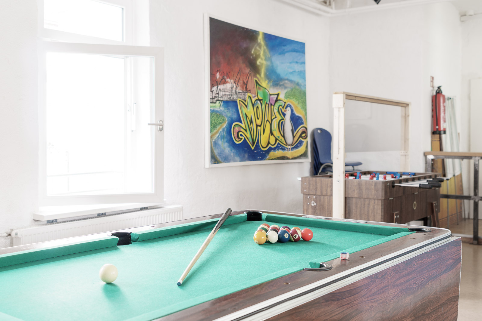 Aufenthaltsraum im Jugendbereich mit Billiardtisch, Tischkicker und Graffitti an der Wand