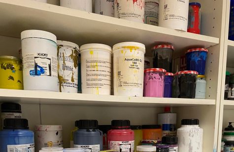 Acrylfarben in verschieden großen Behältern in einem Regal